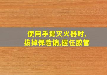 使用手提灭火器时,拔掉保险销,握住胶管